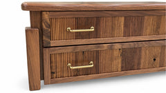 A close-up of a wooden dresser with two drawers featuring vertical slat fronts and brass bar handles, shown against a plain white background.