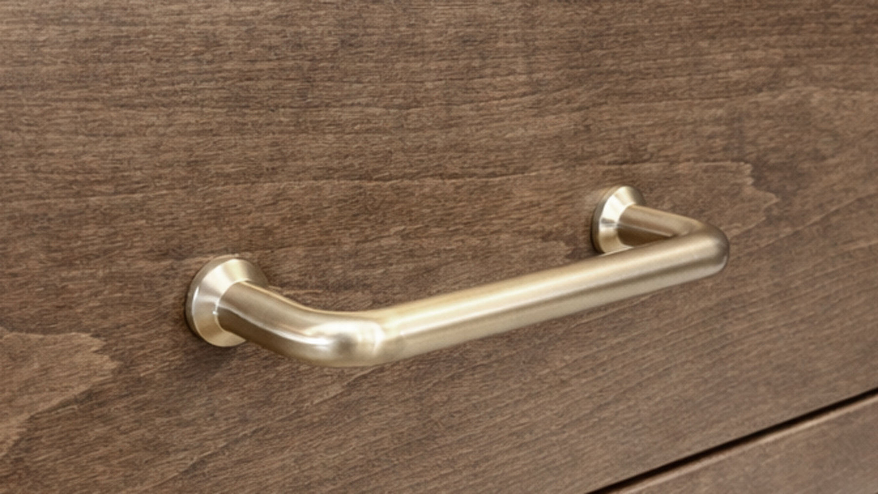 Gold desk handle on a wooden drawer
