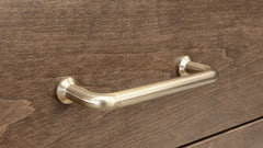 Gold desk handle on a wooden drawer