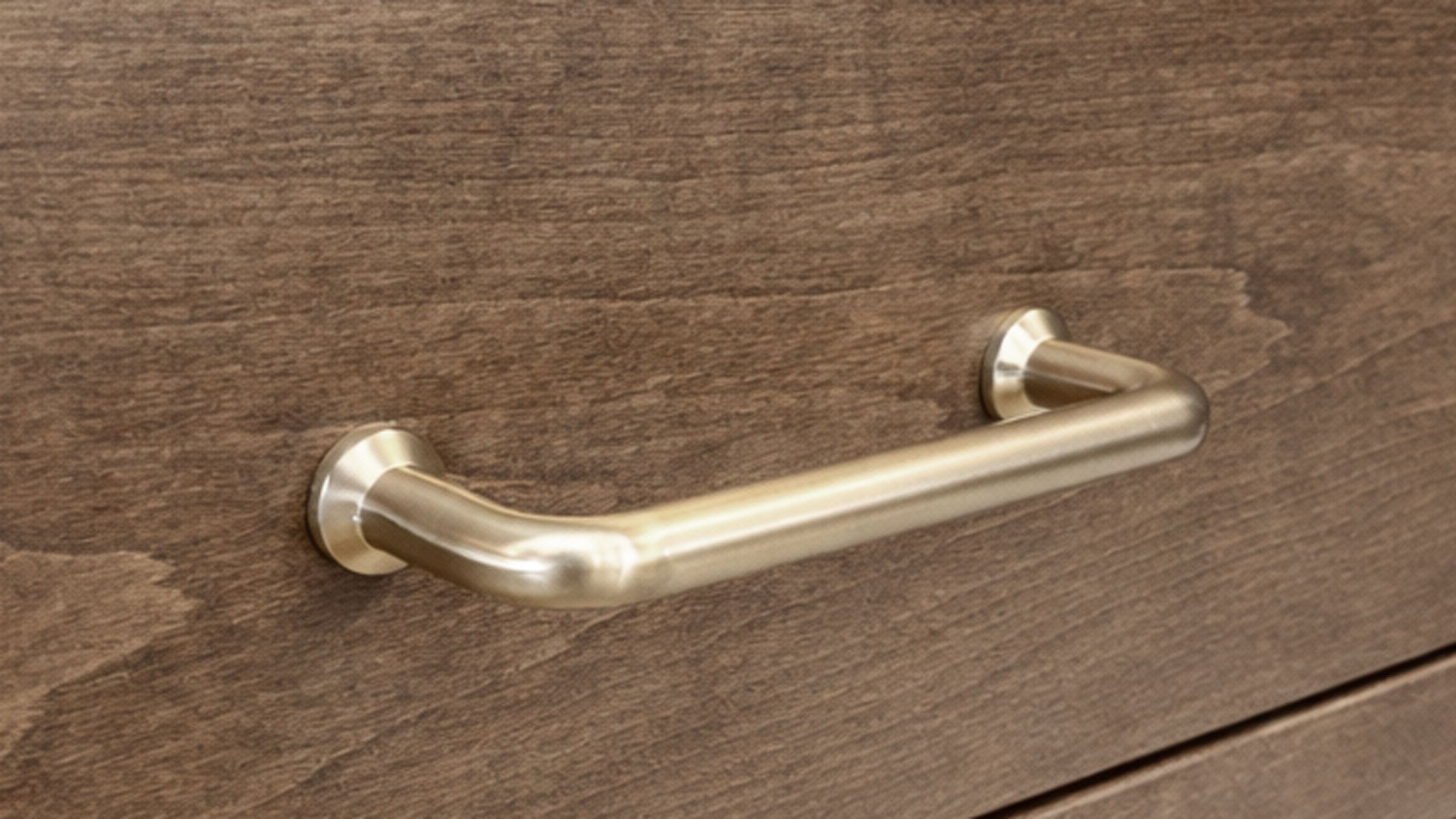 Gold desk handle on a wooden drawer