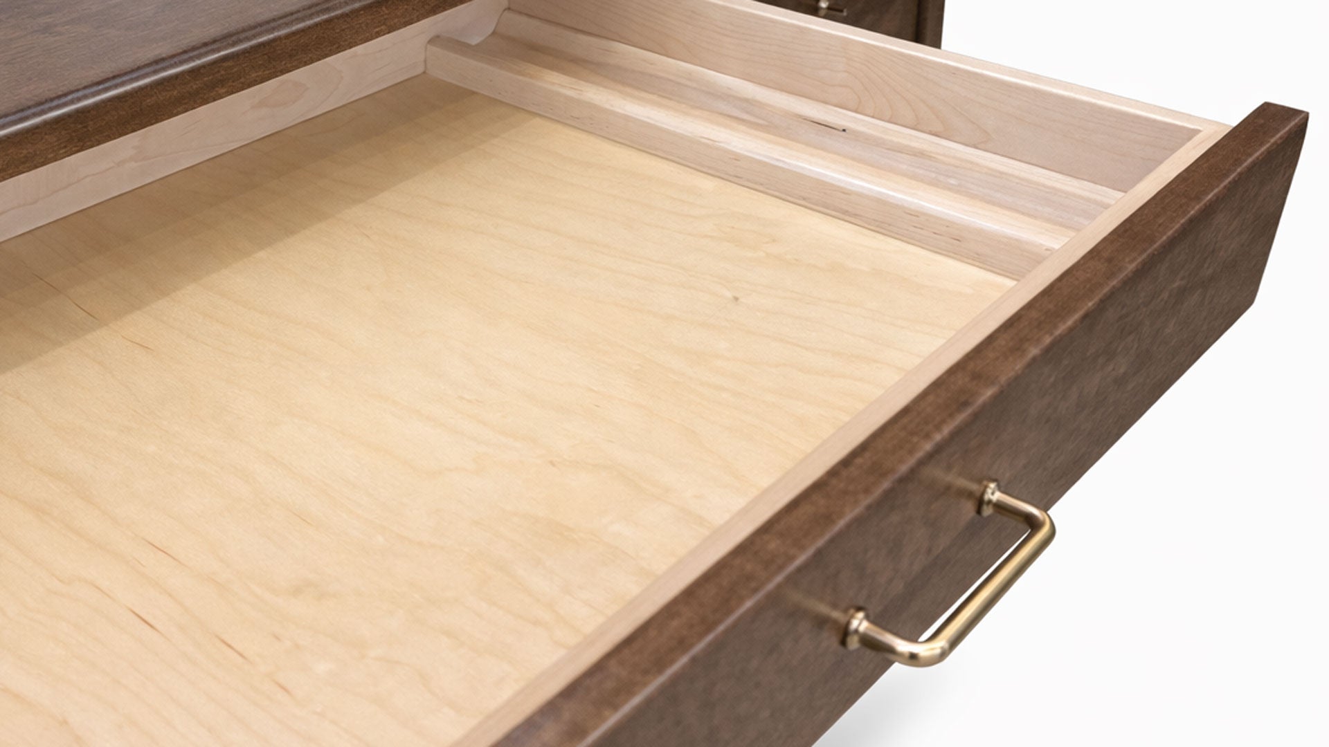 Open wooden drawer with a gold handle on a white background