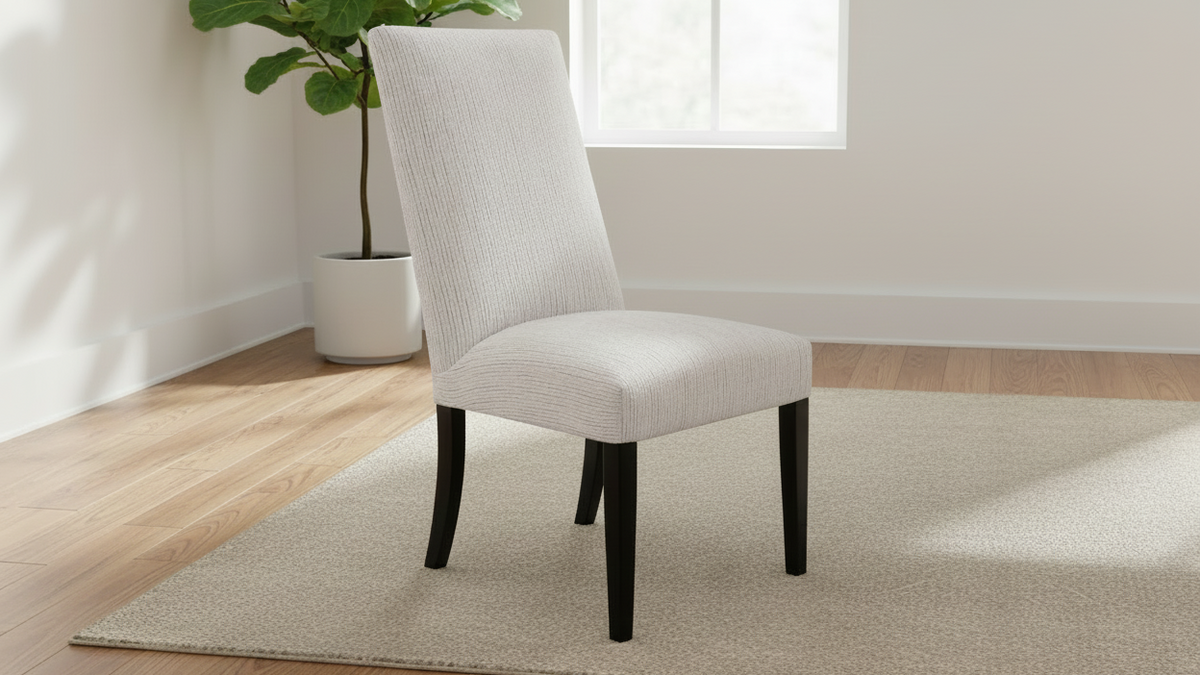 White upholstered chair with black legs on a white background