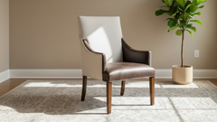 Chair with brown leather seat and beige backrest in a room with a plant and neutral walls.