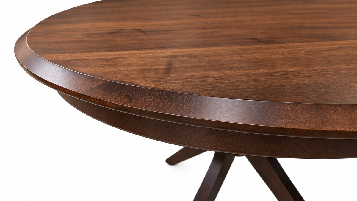 Close-up of a round wooden dining table showing the rich brown wood grain on the tabletop and the dark wood pedestal base against a white background.