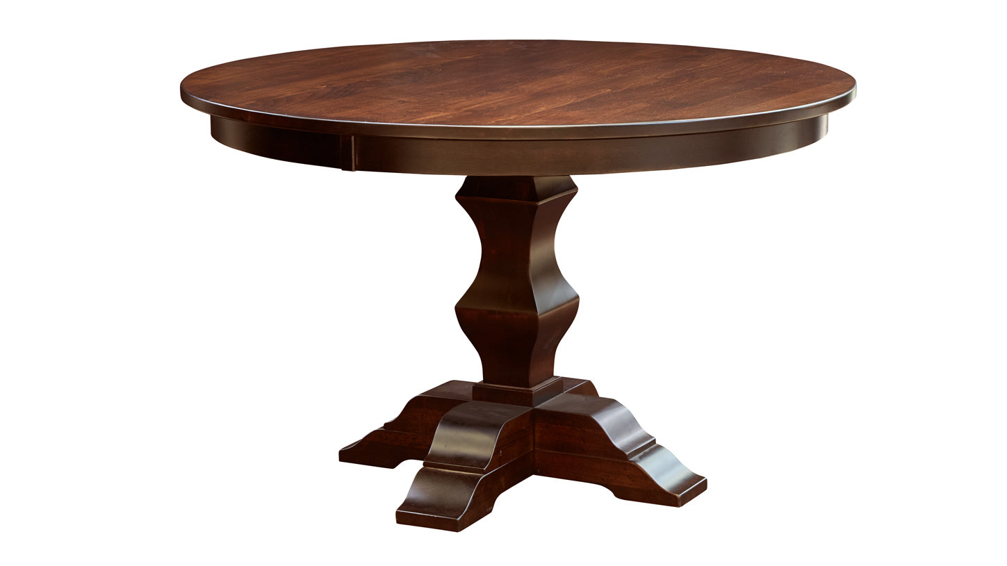 A round brown Magnolia dining table with a pedestal base and curved legs.