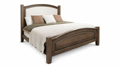 Wooden bed with white bedding and brown pillows on a white background