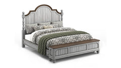 Bed with floral bedding and a wooden headboard on a white background