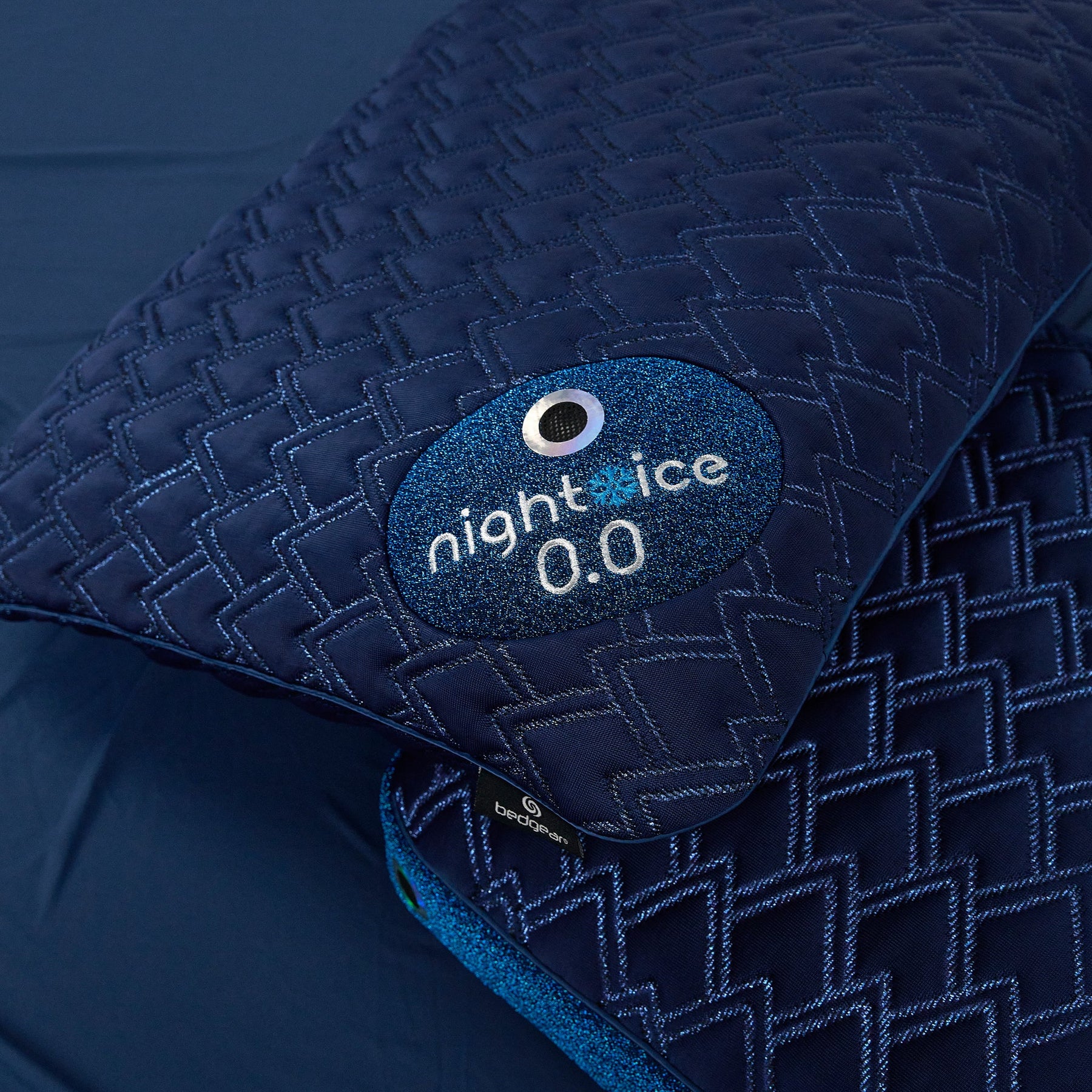 Navy blue quilted jacket with 'night ice' logo on a dark background