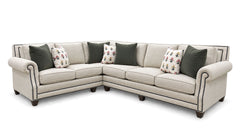 An L-shaped sectional sofa upholstered in light beige fabric with dark green and floral accent pillows, shown on a plain white background.