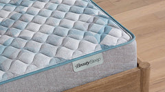 Gray quilted mattress on a wooden bed frame with 'BeautySleep' branding.