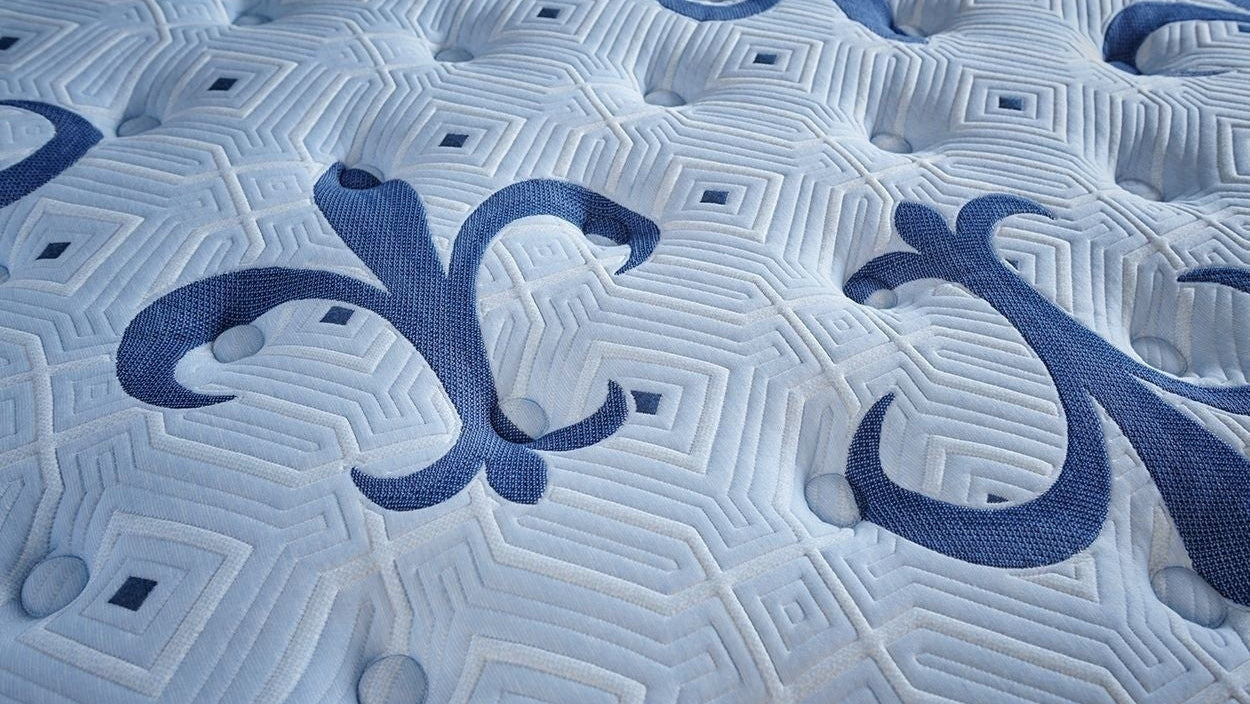 Close-up of a textured mattress surface with a brand logo.