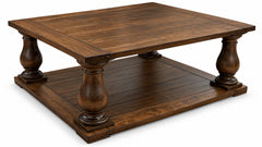A rustic dark brown wooden coffee table with a raised rectangular top, four turned legs, and a matching lower shelf, shown on a white background.