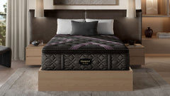 A queen size Beautyrest Black Series 2 Plush Pillowtop Mattress in a bedroom setting, featuring a plush top with a patterned design and a supportive base structure.