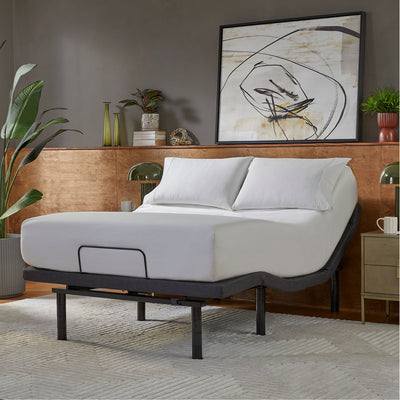 Cama con base ajustable en un dormitorio decorado con plantas y obras de arte.