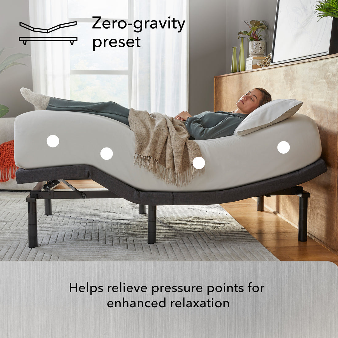 Person lying on a adjustable bed with zero-gravity preset feature in a bedroom setting.