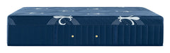 A dark blue quilted mattress shown from a side angle against a white background, featuring decorative white wing-like patterns and two small gold buttons on the side.