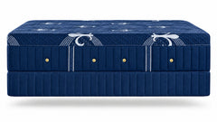 A dark blue upholstered bed frame or mattress base with decorative white scroll motifs and small gold button accents, shown against a plain white background.