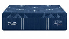 A dark blue mattress shown from a three-quarter angle, resting on a matching dark blue mattress base. The brand name 'STEARNS & FOSTER' is clearly visible on the side of the mattress.
