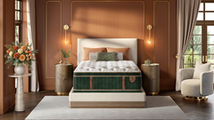 A luxury bed with a tufted white mattress and a dark green velvet side panel, styled in a modern, warm brown bedroom with gold wall accents, side tables, and a matching armchair.