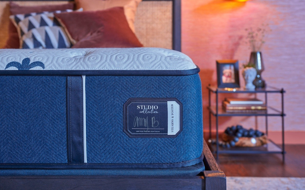 Blue mattress with 'Studio Collection' label in a bedroom setting