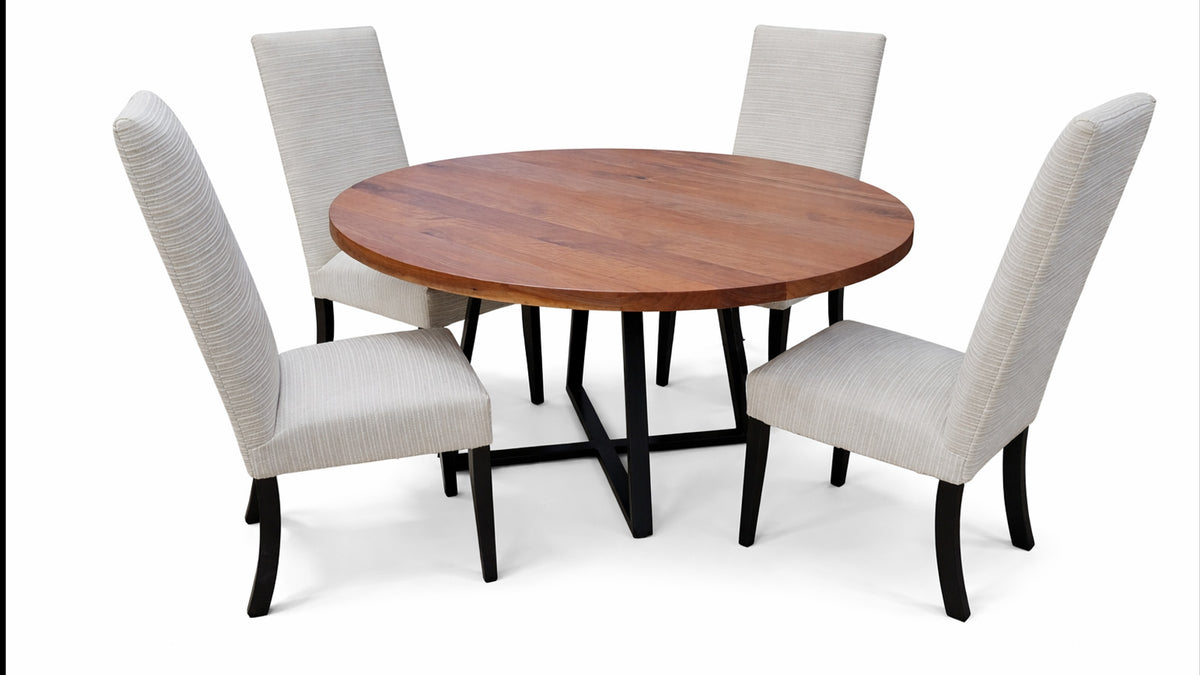 Round wooden dining table with four matching chairs on a white background