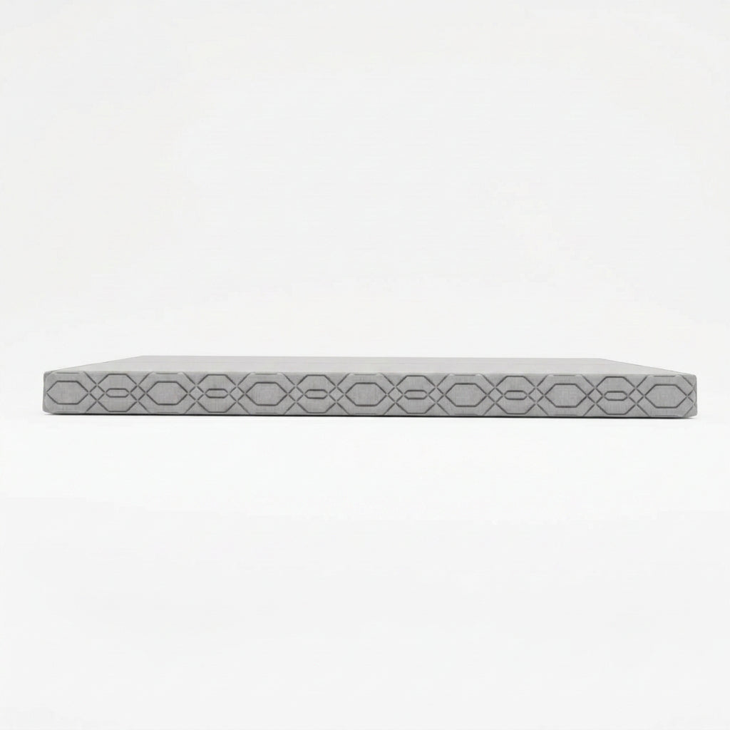A side view of a gray mattress on a solid black background.