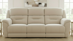 Beige sofa in a room with large windows and a mirror on the wall.