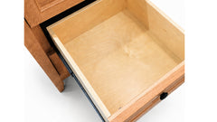 Close-up of a wooden drawer with one drawer pulled open, showing the light natural wood interior and outer drawer frame in a warm medium brown finish, set against a plain white background.