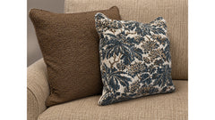 Two pillows, one brown and one with a floral pattern, on a beige couch.