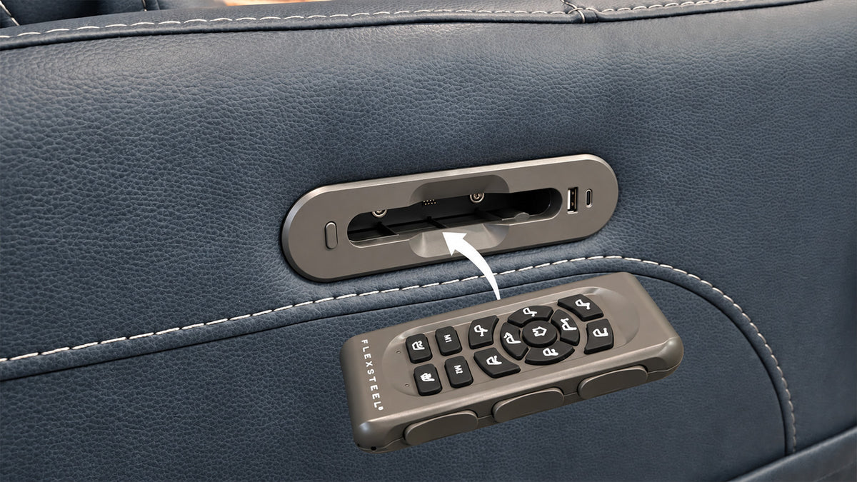 Close-up of a dark blue leather seat or chair with a metallic control panel and a matching remote control attached or resting on the surface.