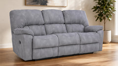 A gray reclining loveseat sofa with a textured microfiber fabric, shown in a living room setting with a wooden floor and a potted plant in the background.