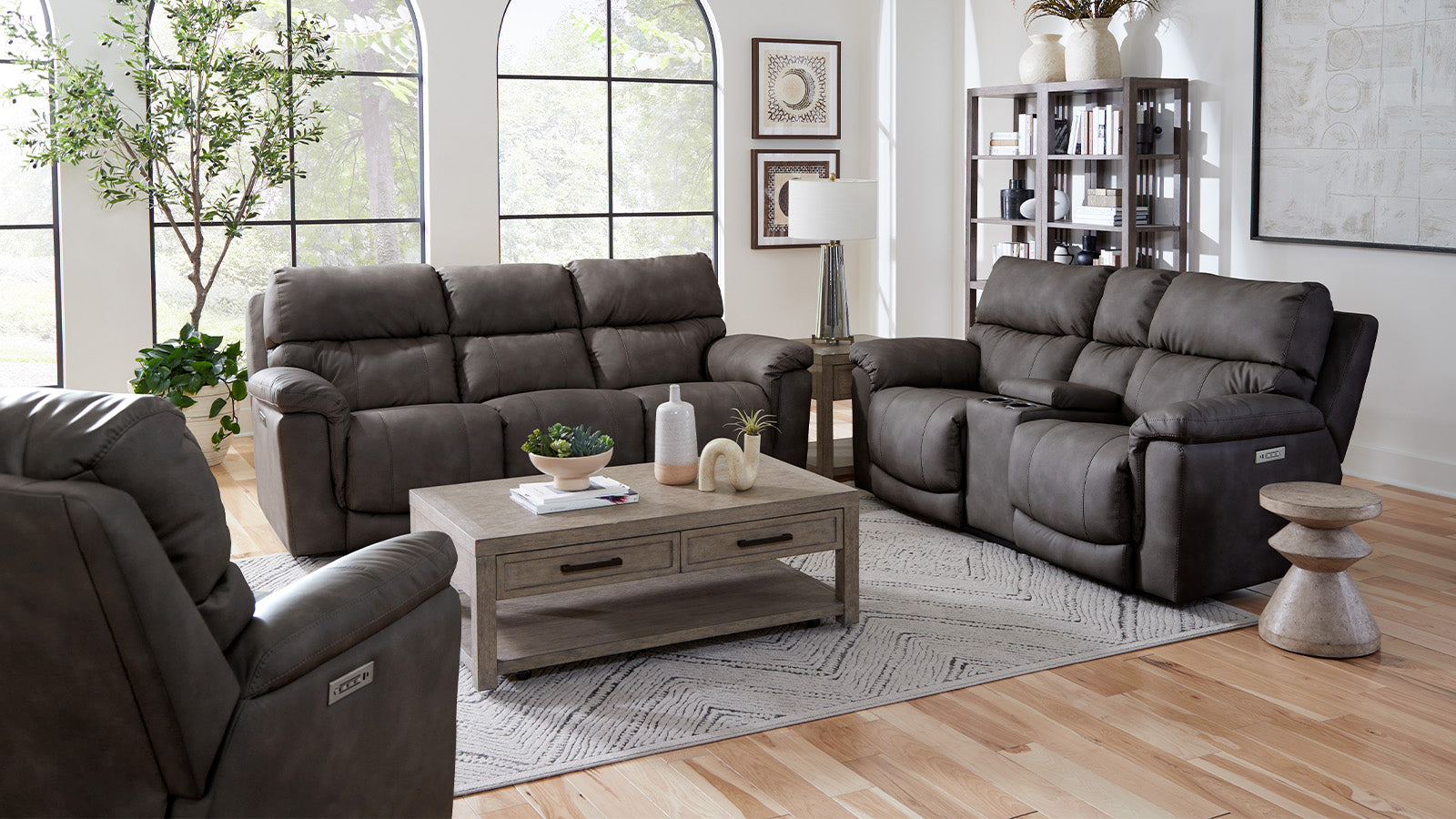 Gray sectional sofa set in a living room with wooden coffee table and decor.