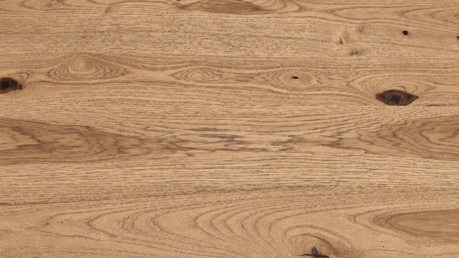 A close-up of a natural wood surface with visible grain, knots, and warm tan-brown tones.